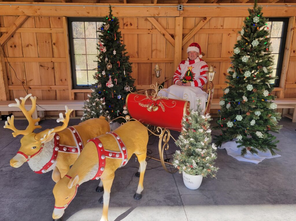 A festive Barn Venue Maryland Christmas scene featuring a sleigh, reindeer, and holiday lights at Timber Valley Farm.
