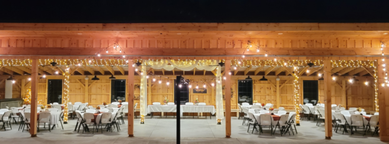 A beautiful view of Timber Valley Farm Barn Rental Wedding and Event Venue at dusk, showing the transition from sunset to evening with soft lighting across the farm grounds.
