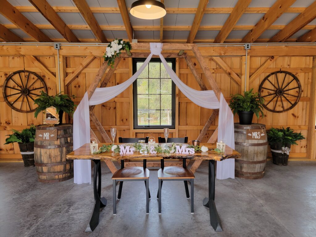 Features that Define The Venue at Timber Valley Farm Barn Rental Clear Spring Maryland
Our commitment to quality and unique design sets us apart as the premier event space in Western Maryland.
True Timber Frame Barn: The robust, exposed wooden beams provide an authentic rustic charm and a magnificent backdrop for photography.
Majestic Sliding Barn Doors: These doors serve as both a dramatic focal point and a functional element, effortlessly blending the indoor reception area with the outdoor scenery.
Versatile Event Space: The Venue at Timber Valley Farm Barn Rental Clear Spring Maryland is climate-controlled and flexible, accommodating everything from grand weddings to focused business conferences.