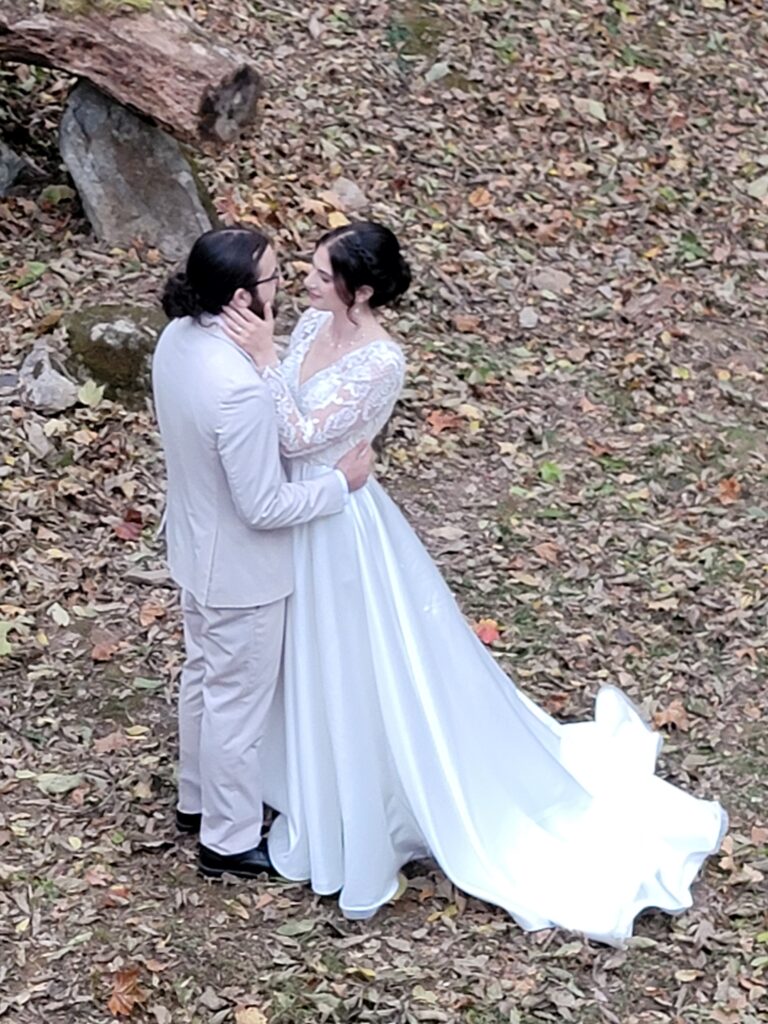 Matthew and Abigail sharing an intimate look in the wooded sanctuary of The Cove at Timber Valley Farm Barn Rental Wedding and Event Venue, surrounded by fallen leaves.