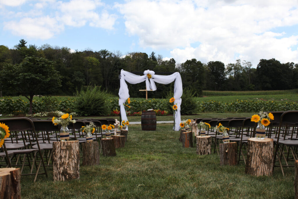 Rustic Wedding Arch decorated with sunflowers overlooking the valley and The Cross at Timber Valley Farm Barn Rental in Clear Spring, Maryland.