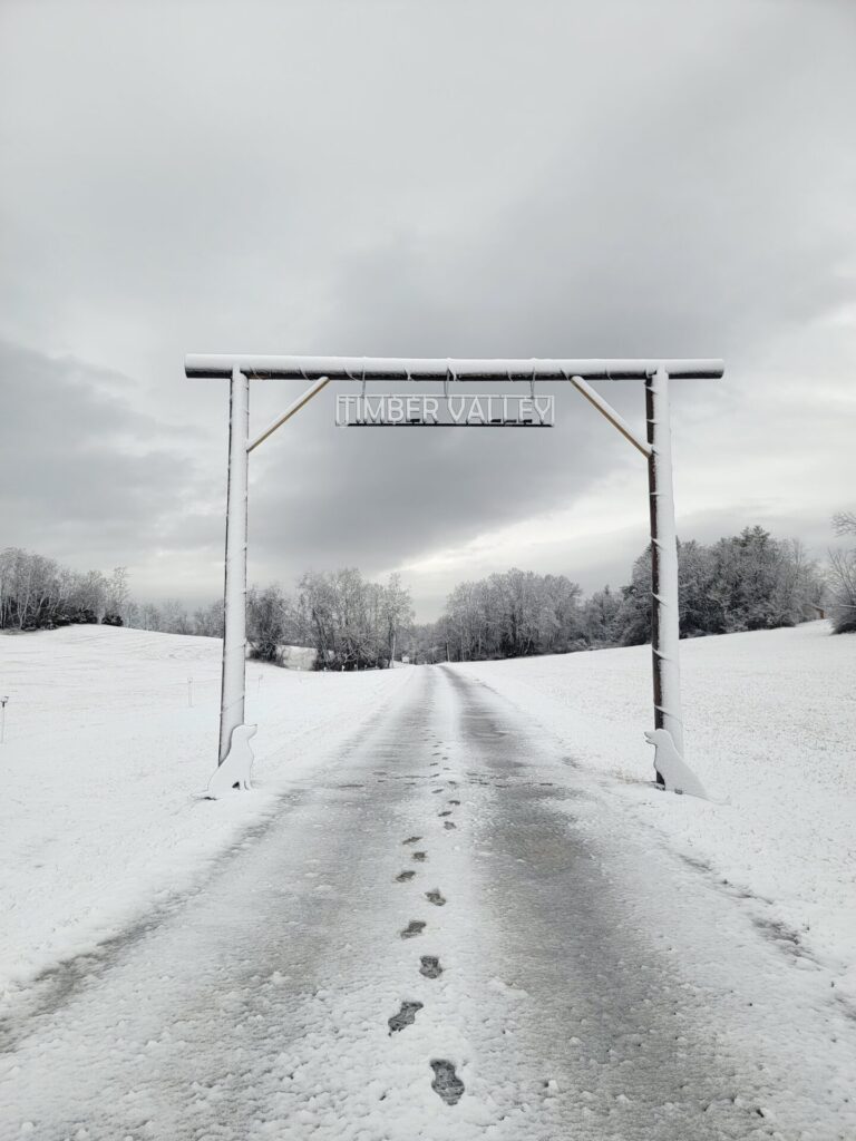 Snow-covered Timber Valley entrance welcomes visitors to Timber Valley Farm Barn Rental, a peaceful Snow Wedding Venue Maryland surrounded by rolling hills and winter countryside.