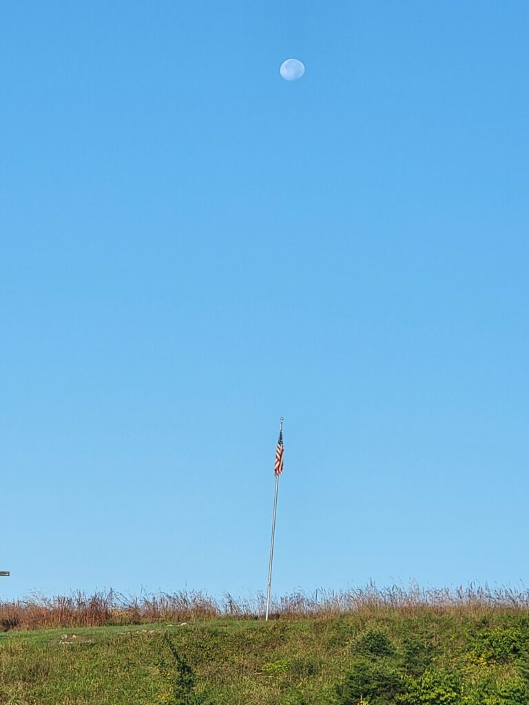 Morning moon above the American flag at Timber Valley Farm Barn Rental following Moonlit Nights at Timber Valley, highlighting the beauty of Maryland Moonlight Photography.
