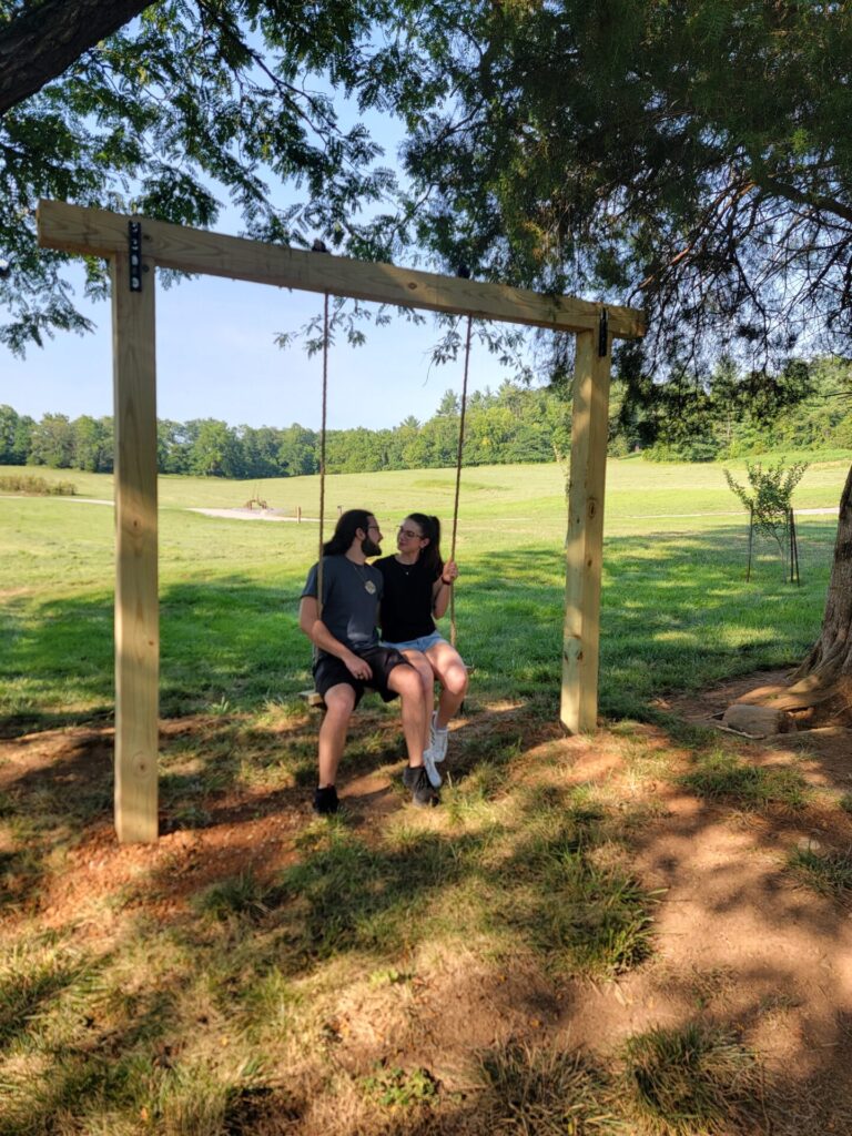 Couple relaxing on the Timber Valley swing during a Private Wedding Venue Tour at Timber Valley Farm Barn Rental in Clear Spring, Maryland.