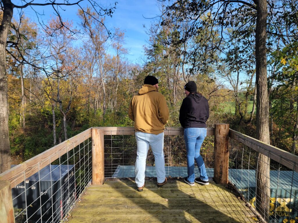 Couple exploring the Timber Valley Railroad Overlook during a Private Wedding Venue Tour at Timber Valley Farm Barn Rental in Clear Spring, Maryland.