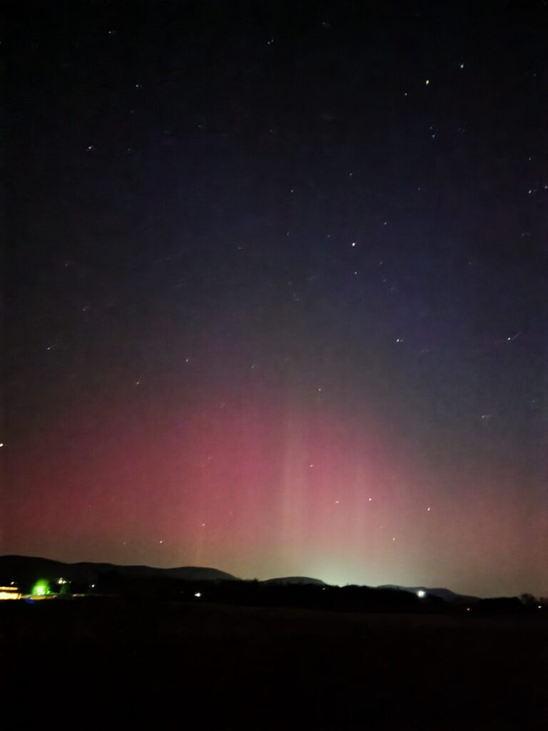 The rare Northern Lights illuminate the night sky above Timber Valley Farm Barn Rental in Clear Spring, Maryland, creating an unforgettable Maryland Dark Sky Experience.
