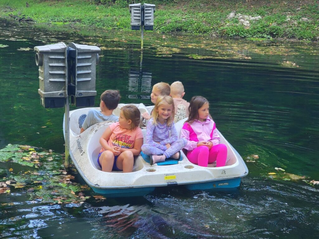 Six children in a paddle boat, away from phones and screens, laughing, exploring, and making memories together.

That is what the Spring-Fed Pond is really about.