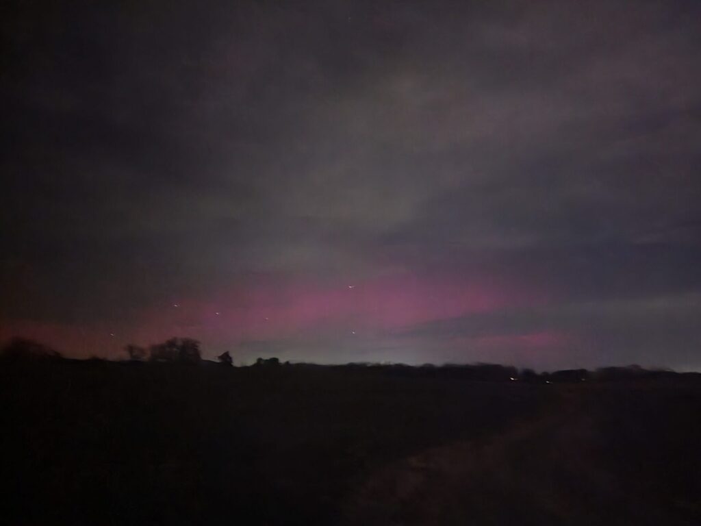 Northern Lights glowing above the fields at Timber Valley Farm Barn Rental in Western Maryland during a rare Aurora Borealis event.