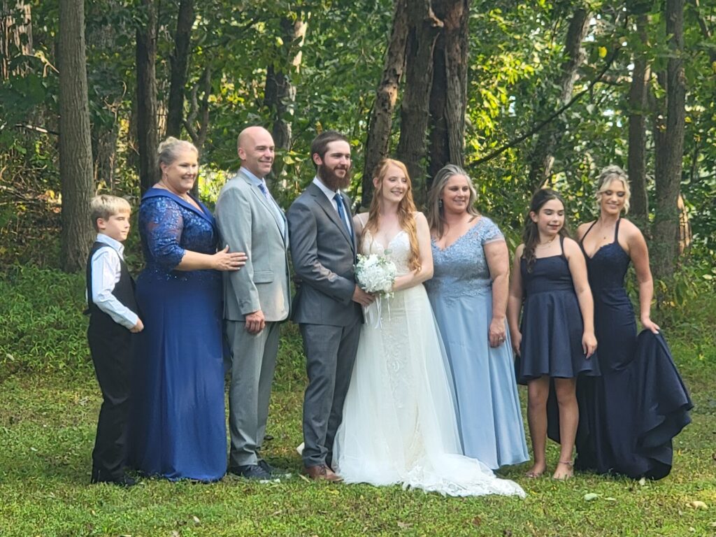 Bride and groom posing with family members near the Timber Valley Retreat Cabins at Timber Valley Farm Barn Rental in Clear Spring, Maryland.