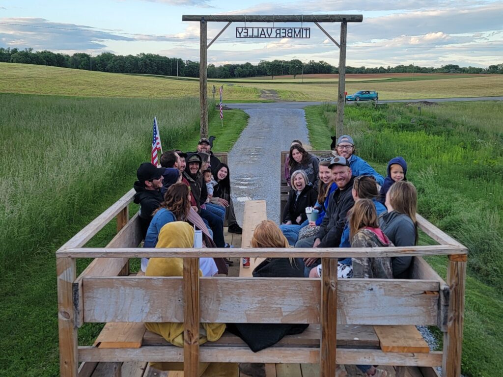 Wedding guests enjoy a Timber Valley Trailblazer wagon ride during a Friday wedding weekend at Timber Valley Farm Barn Rental in Clear Spring, Maryland.