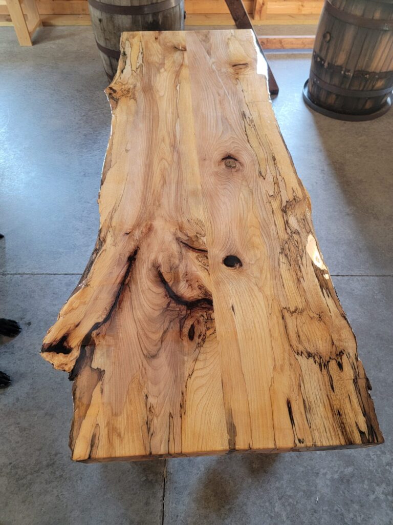 Close-up of a handcrafted Live Edge Sweetheart Table highlighting the natural wood grain, live edge, and unique character at Timber Valley Farm Barn Rental in Clear Spring, Maryland.