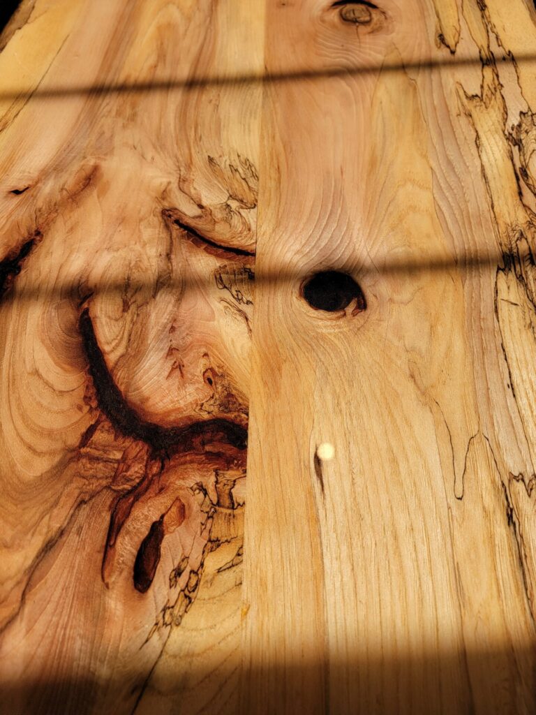 Close-up of the natural grain and live edge craftsmanship on a handcrafted Live Edge Sweetheart Table at Timber Valley Farm Barn Rental in Clear Spring, Maryland.