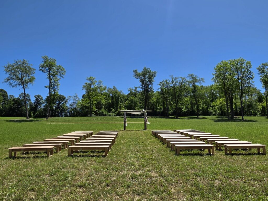Outdoor Wedding Ceremony Arbor with wooden guest seating overlooking the countryside at Timber Valley Farm Barn Rental in Clear Spring, Maryland.