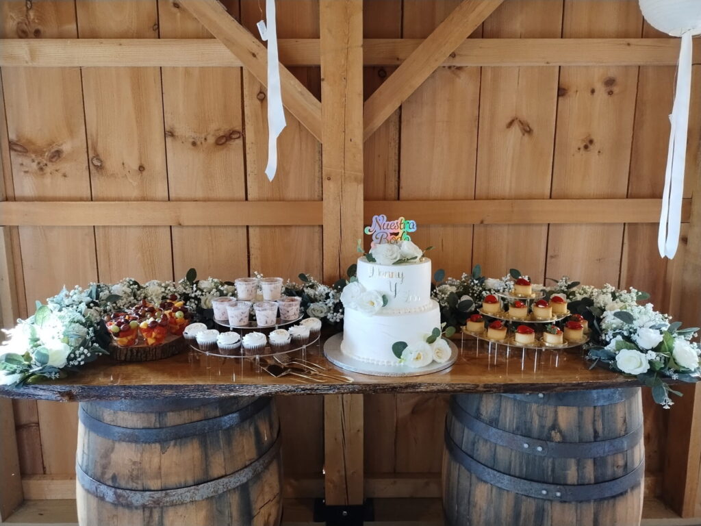 Wedding Guest Experience Maryland featuring a personalized wedding cake, fruit, cupcakes, desserts, and flowers at Timber Valley Farm Barn Rental