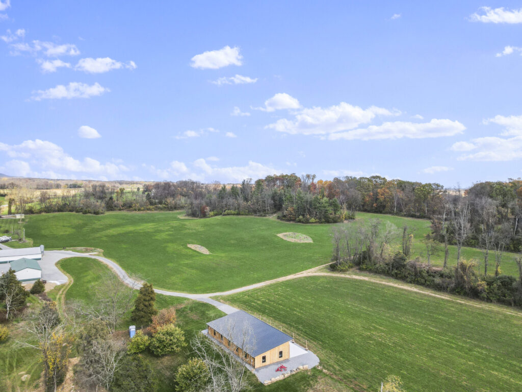 Maryland countryside surrounding Timber Valley Farm Barn Rental with open fields, wooded areas, rolling hills, and timber-frame wedding barn