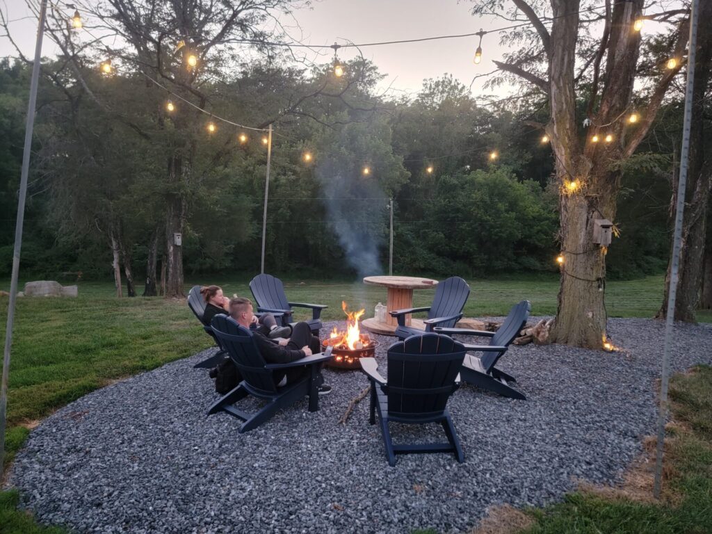 Wedding Guest Experience Maryland with guests relaxing around the firepit at Timber Valley Farm Barn Rental beneath string lights
