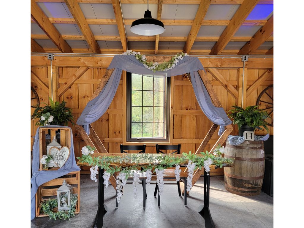 Decorated Hexagon Wedding Backdrop with a handcrafted Live Edge Sweetheart Table inside the timber-frame barn at Timber Valley Farm Barn Rental in Clear Spring, Maryland, inspiring ceremony, sweetheart table, and wedding photo backdrop ideas.