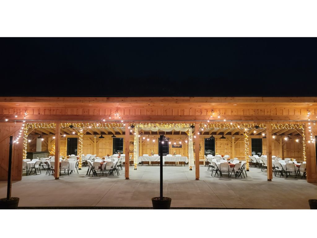 Outdoor Wedding Reception Decorations featuring warm café string lights illuminating the timber frame barn patio at Timber Valley Farm Barn Rental in Clear Spring, Maryland.