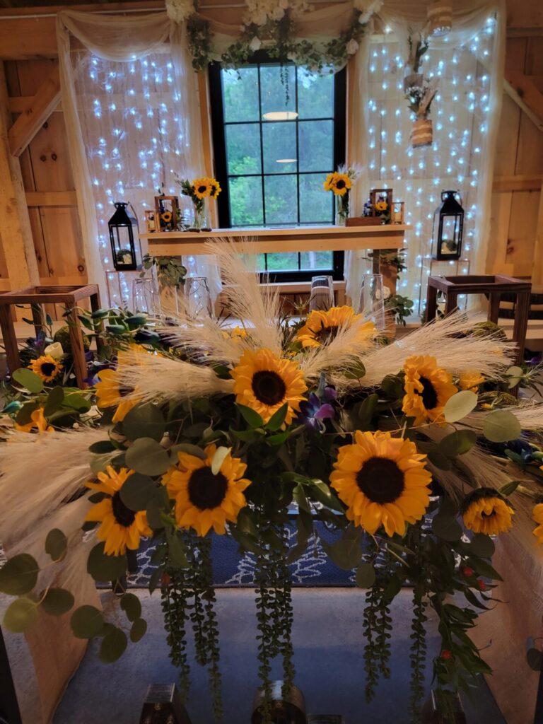 Rustic Wedding Reception Decorations featuring a beautifully decorated sweetheart table with a Mr. & Mrs. sign inside the handcrafted timber frame barn at Timber Valley Farm Barn Rental in Clear Spring, Maryland.