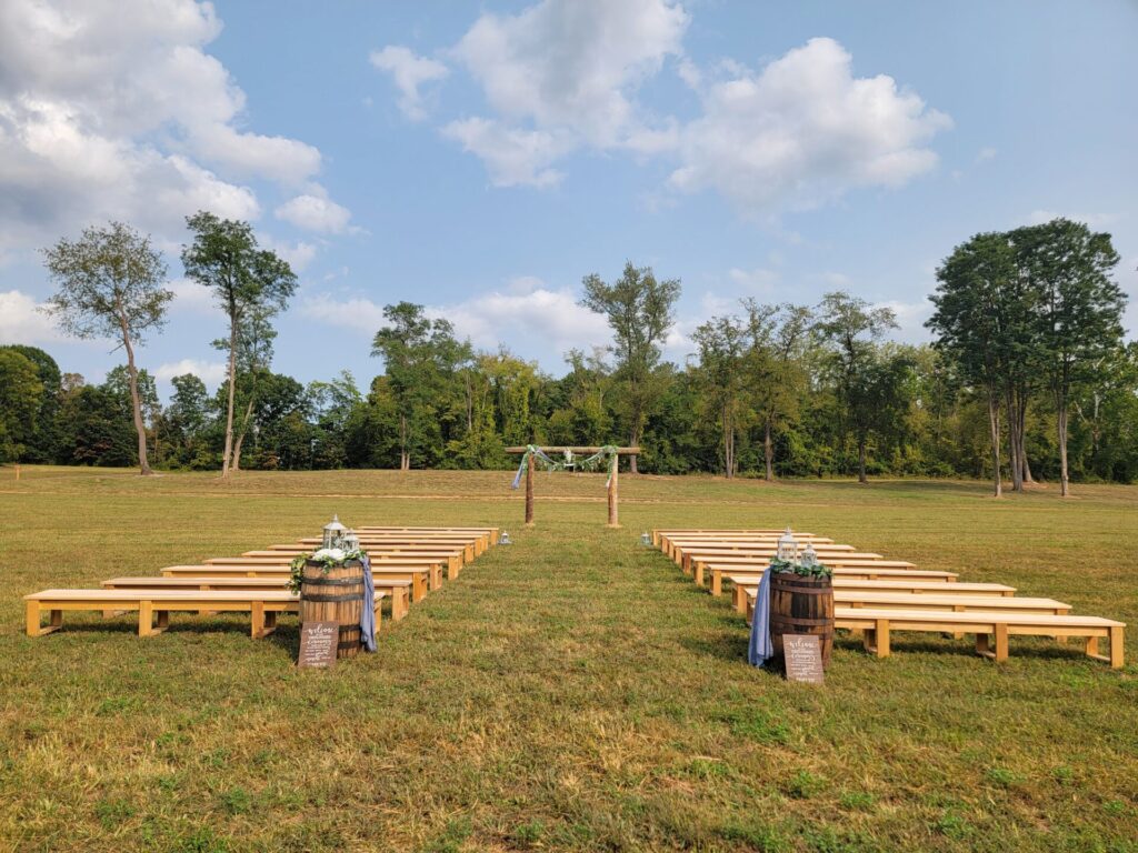 Outdoor Wedding Ceremony Arbor with handcrafted guest seating and countryside views at Timber Valley Farm Barn Rental in Clear Spring, Maryland.