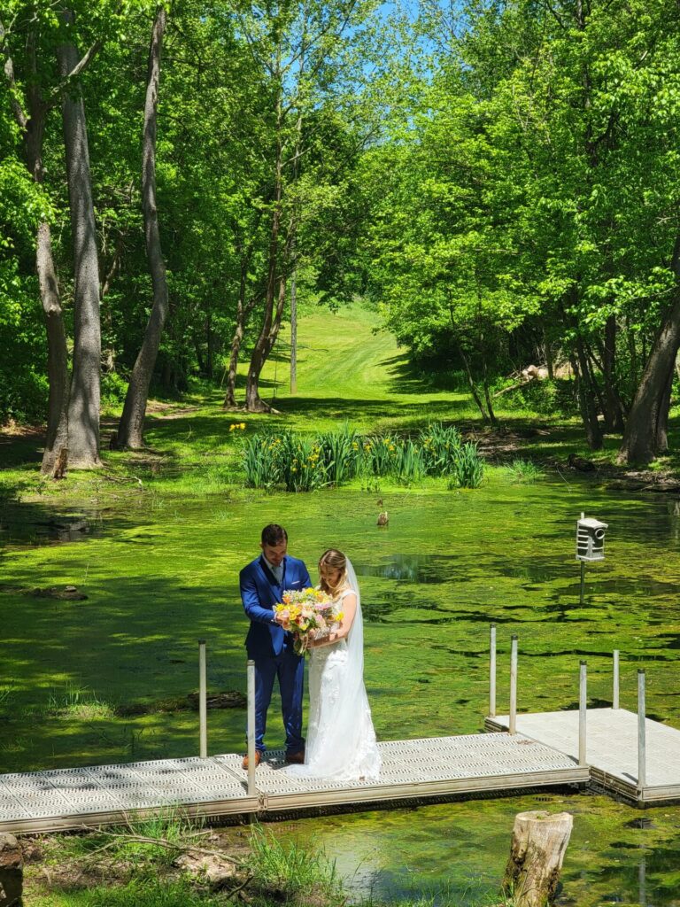 Wedding Ceremony Tips featuring a bride and groom sharing a quiet moment during wedding portraits beside the pond at Timber Valley Farm Barn Rental in Clear Spring, Maryland.