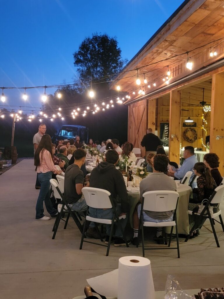 Outdoor Reception Venue Maryland featuring guests enjoying the patio beneath café string lights at Timber Valley Farm Barn Rental in Clear Spring, Maryland.