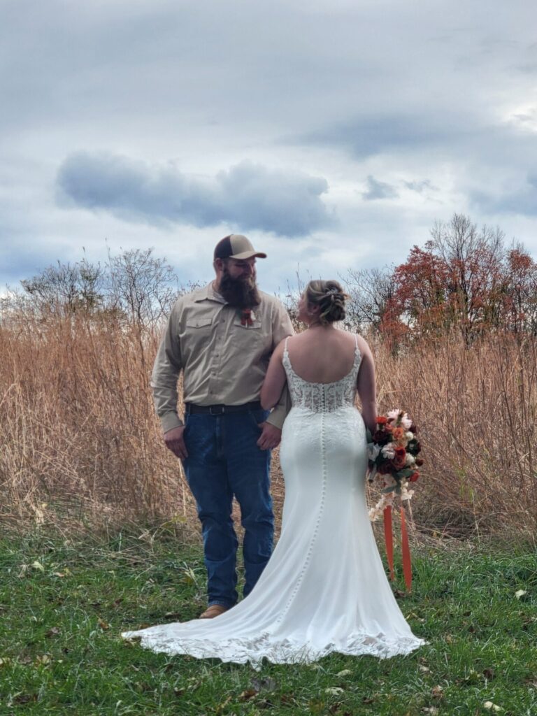 Outdoor Wedding Backdrop with a couple surrounded by tall grasses and autumn foliage at Timber Valley Farm Barn Rental in Clear Spring, Maryland.